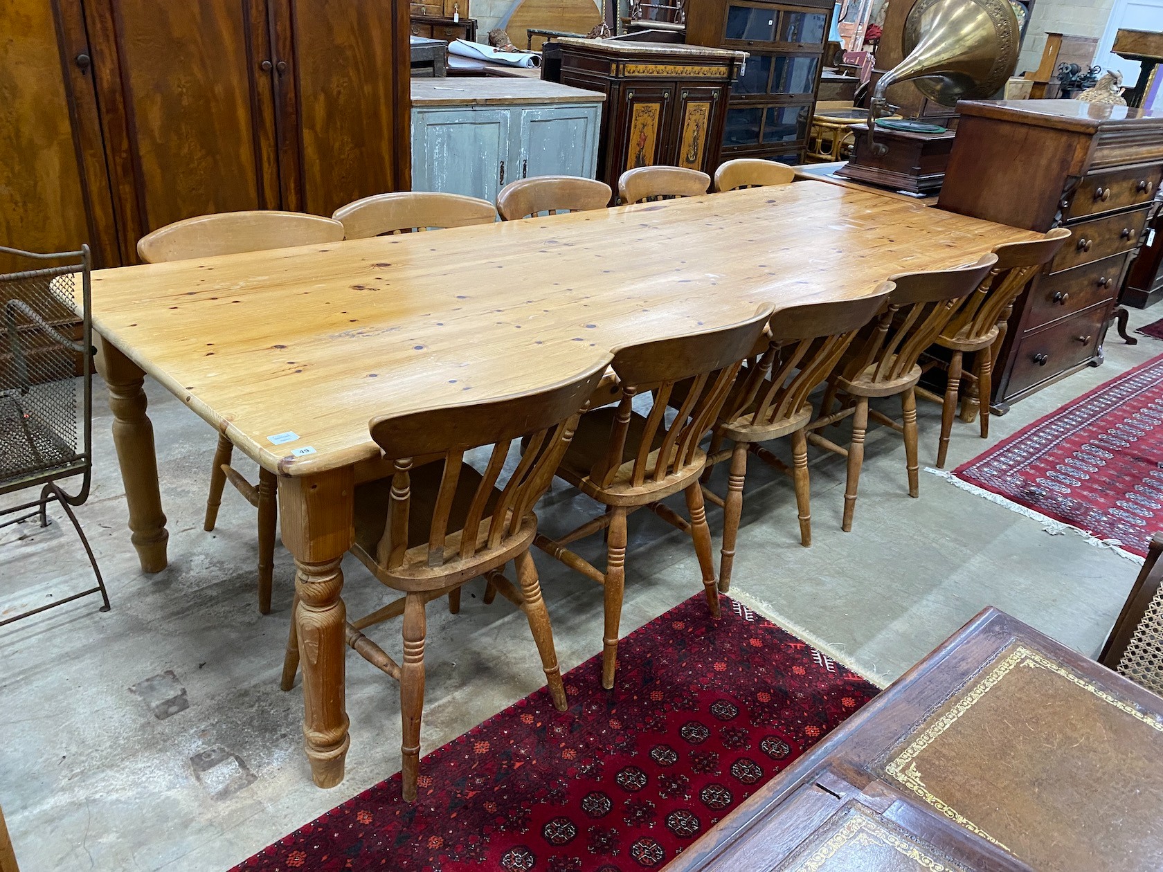 A large Victorian style rectangular pine kitchen table, length 305cm, depth 105cm, height 76cm and ten lathe back beech Windsor kitchen chairs